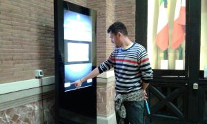 Un visitatore ricerca informazioni sul totem touch screen